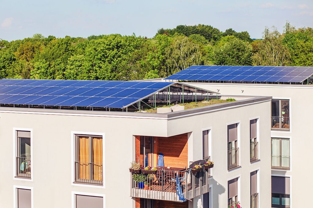panneaux photovoltaïques sur un immeuble à appartements avec toiture végétalisée