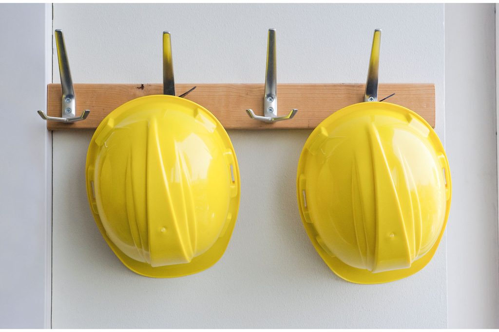 casques de chantier jaunes suspendus à un porte-manteau