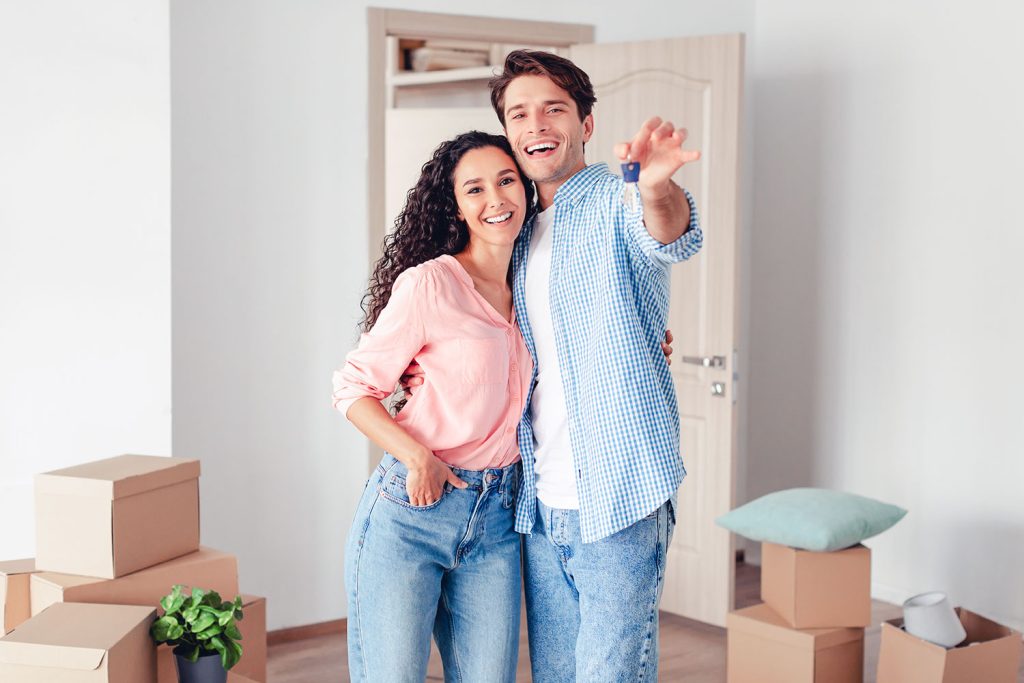 Un jeune couple montre la clé de sa nouvelle maison
