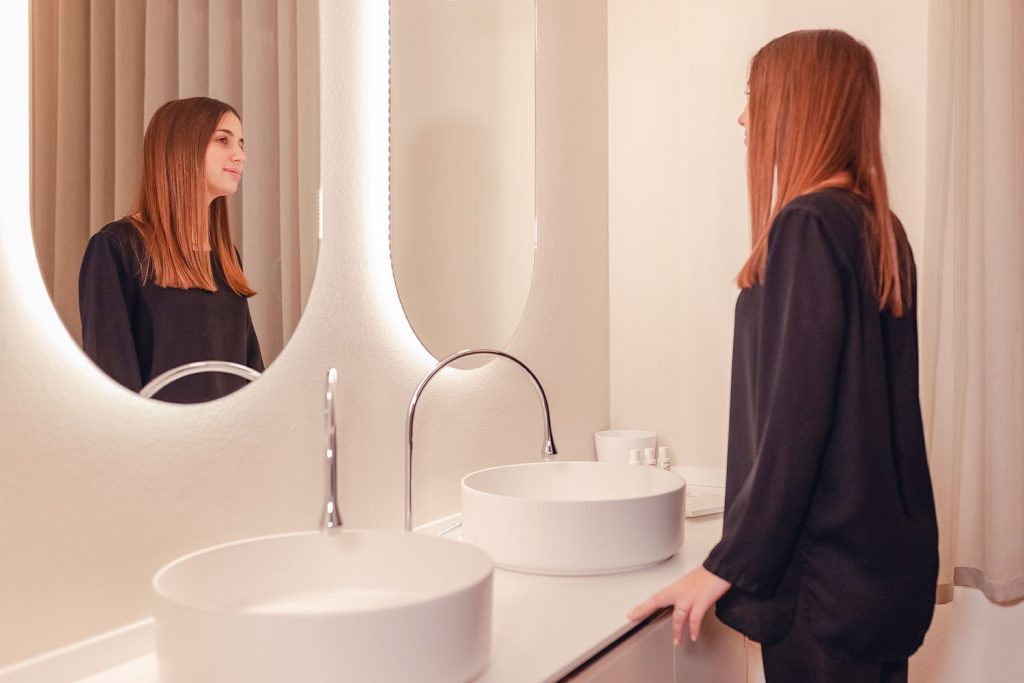 jeune femme devant miroir dans salle de bains moderne