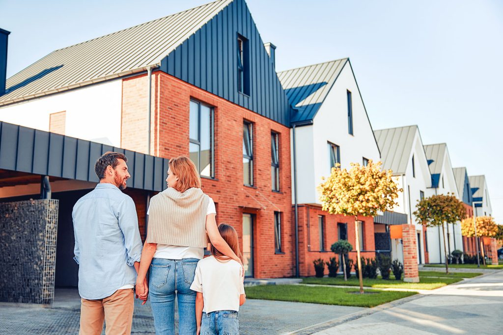 couple avec enfant devant une nouvelle habitation