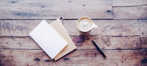 Kopje koffie met notitieboekjes en pen op de achtergrond van de vloer