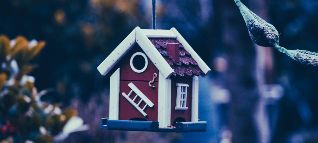 Bien immobilier en miniature sur fond bleu, choisir le prêt hypothécaire adapté