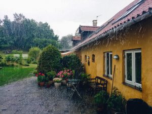 Huis met een grote tuin in de regen
