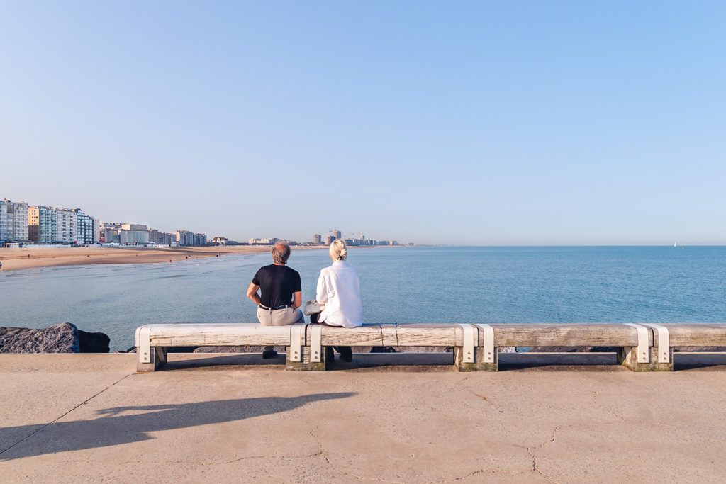 couple assis sur un banc à la côte belge