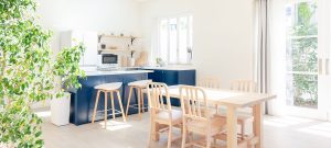 lichtrijke keuken met witte muren en houtkleurige eettafel
