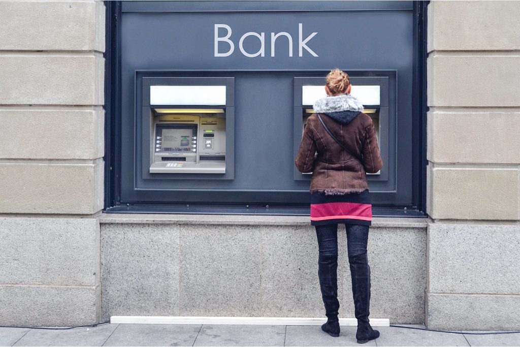 vrouw haalt geld af aan bankautomaat 
