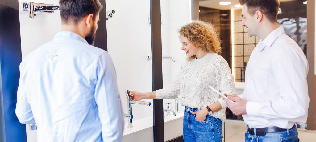 jeune couple examine robinet dans showroom de salles de bains