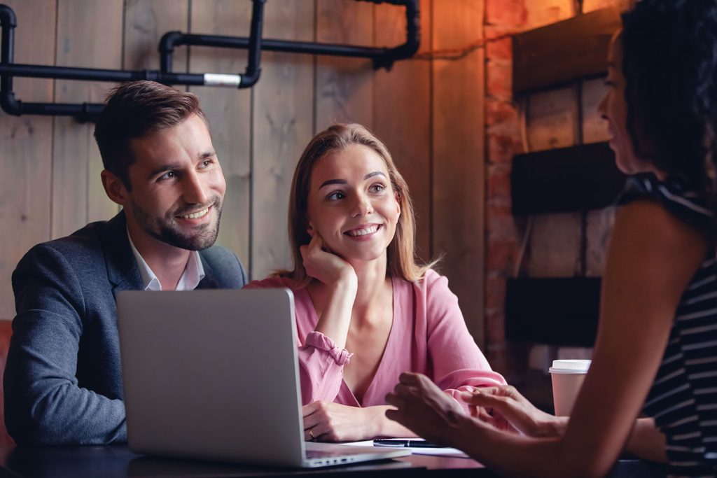 jeune couple content discute avec agent