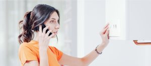 femme téléphone face à un chauffe-eau en panne