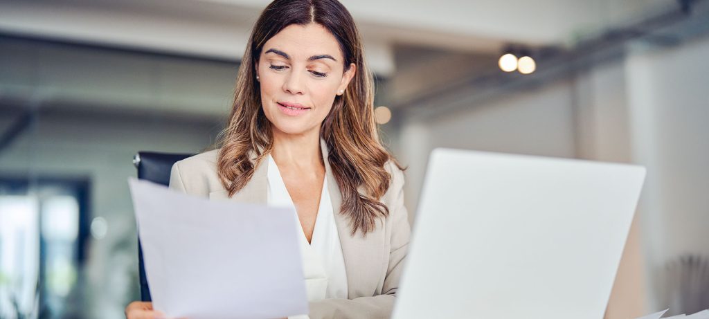 une femme avec un ordinateur portable vérifie le contrat