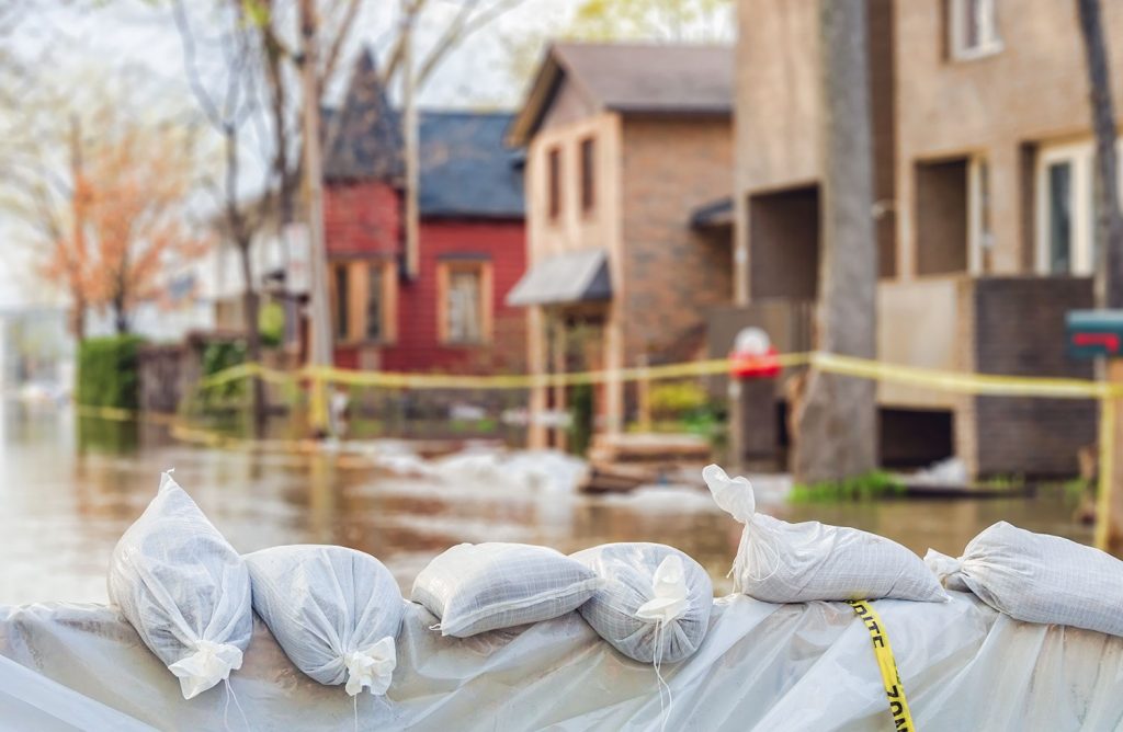 gros plan sur des sacs de sable devant un quartier inondé