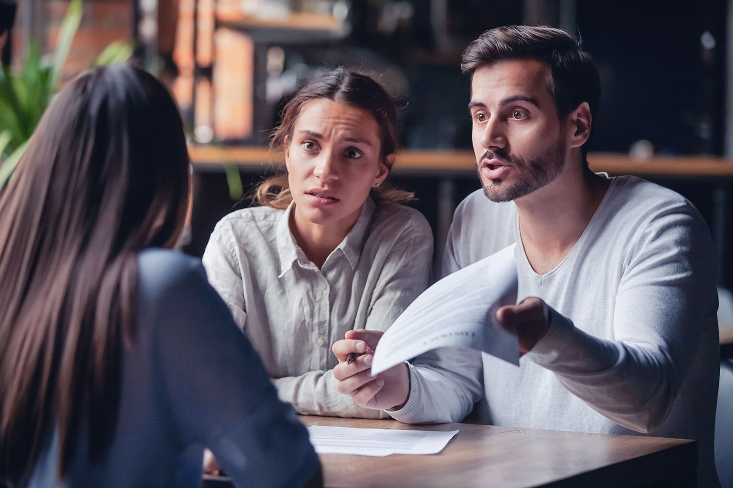 jeune couple agacé pendant la discussion d’un contrat