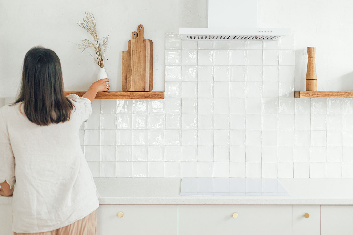 femme aménage une cuisine carrelée blanche