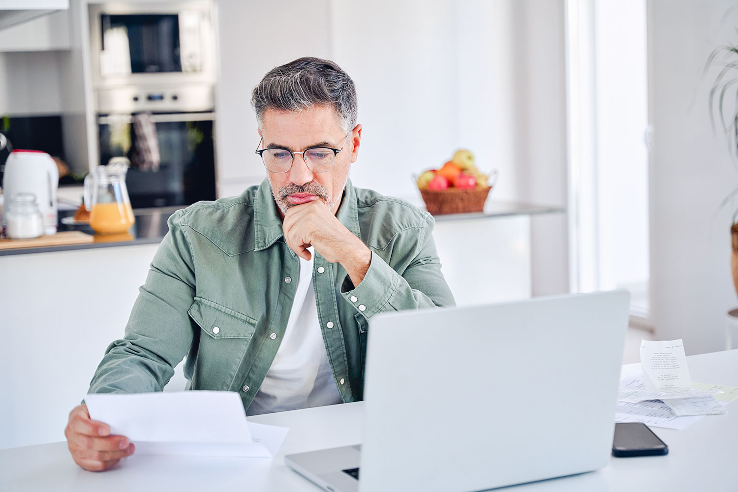 homme contrôle ses finances derrière un portable