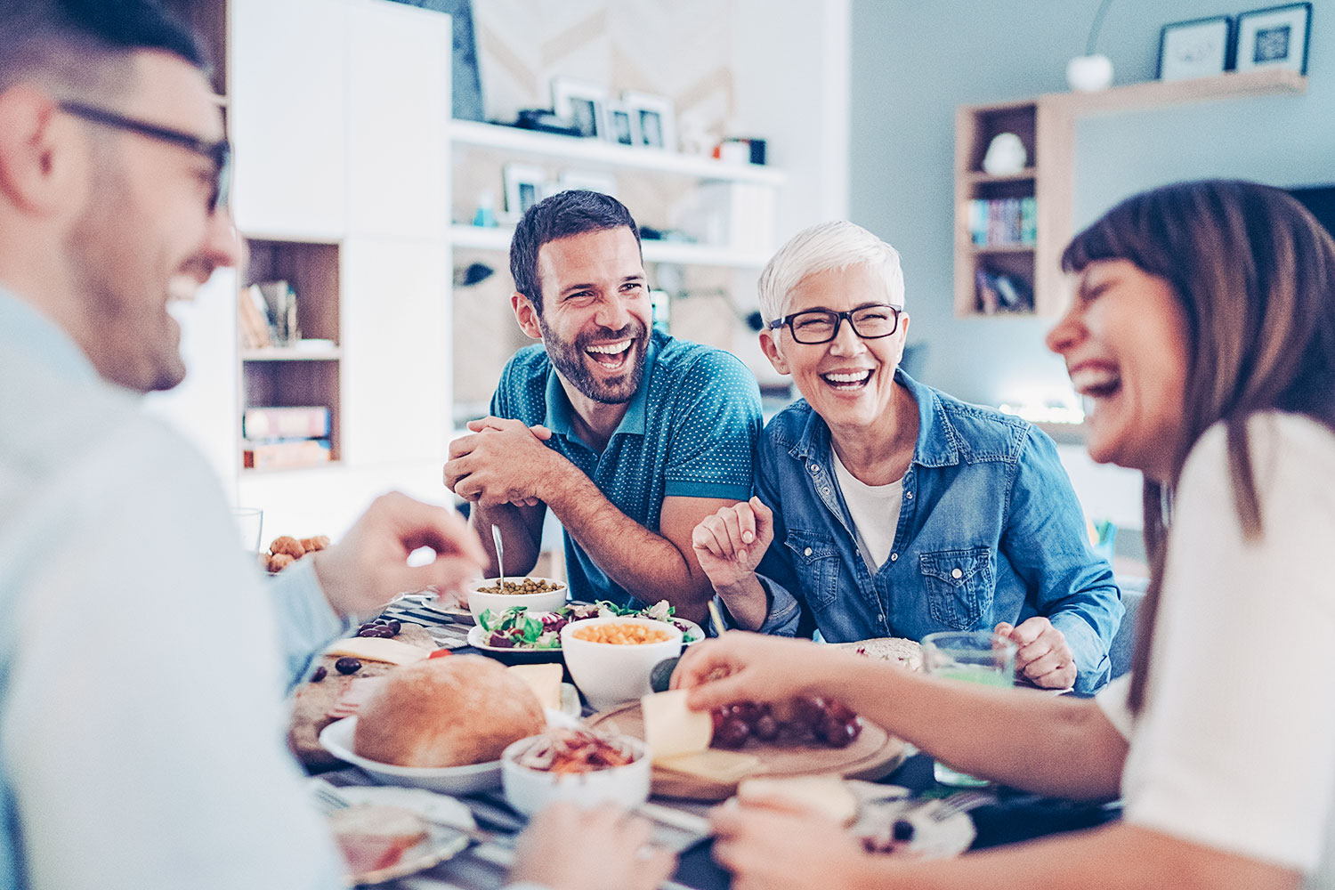 famille ou groupe d’amis rigole autour d’une table pendant un repas